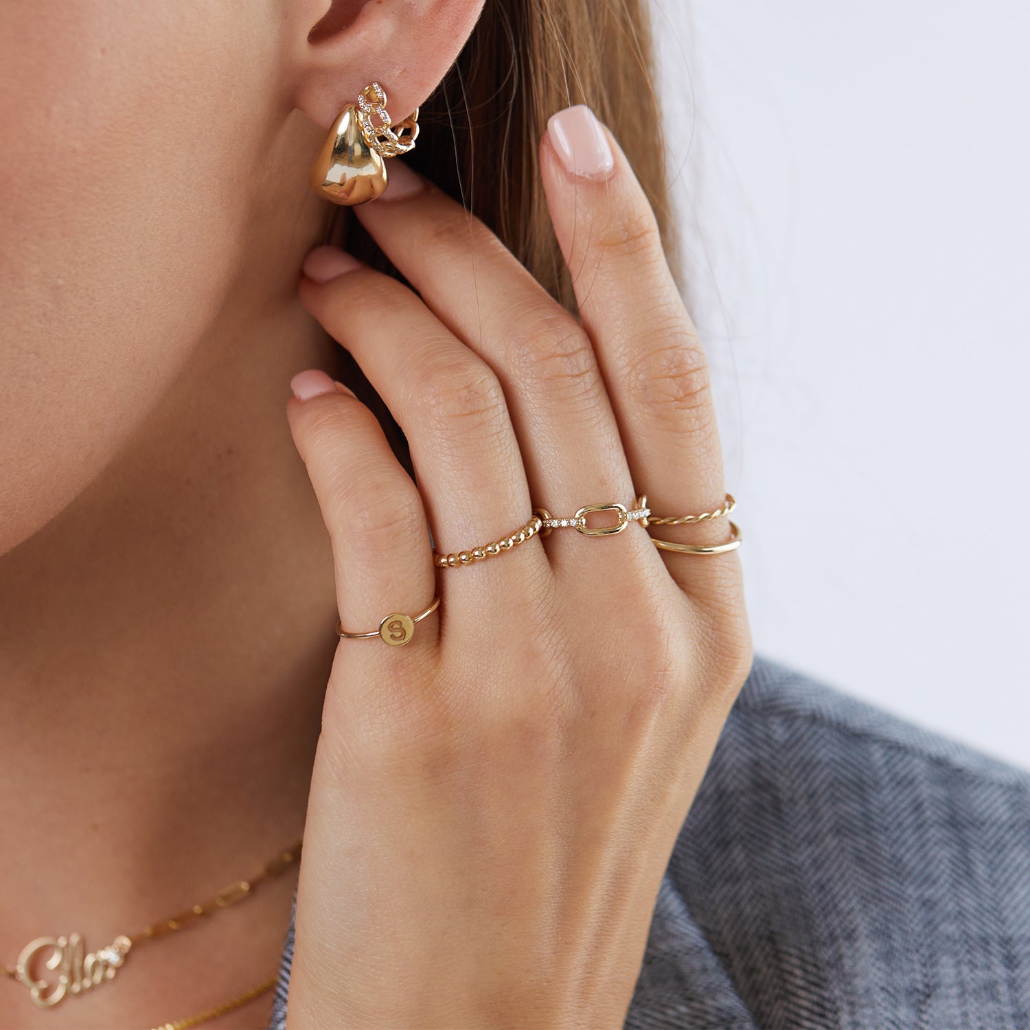 14K gold dome eternity ring worn on hand close up stackable fine jewelry chunky earrings chunky rings dainty rings