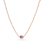 A strand necklace of micro pink pearls with a star shaped purple pearl in the center.