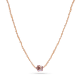 A strand necklace of micro pink pearls with a star shaped purple pearl in the center.