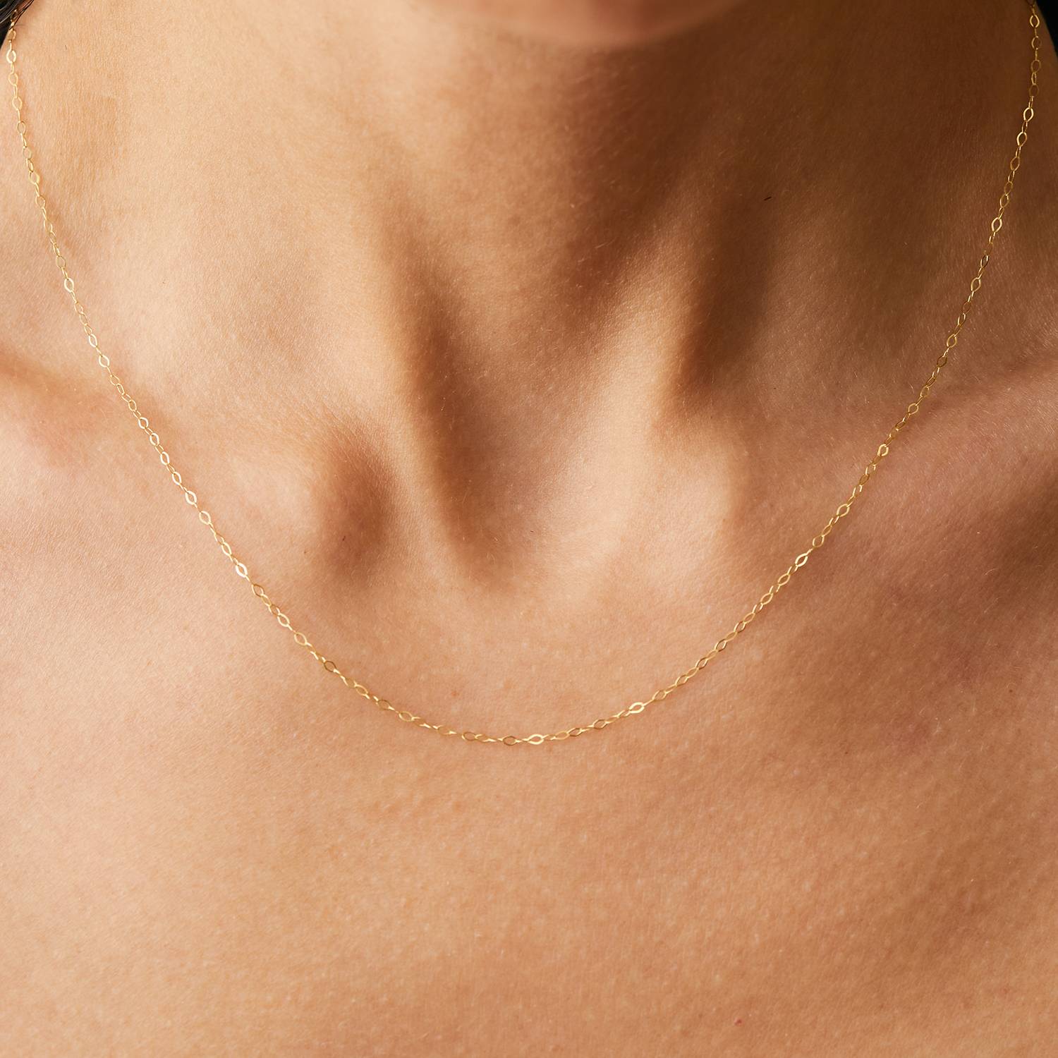 Model wearing 14k solid gold dainty cable chain necklace with kite shaped links.