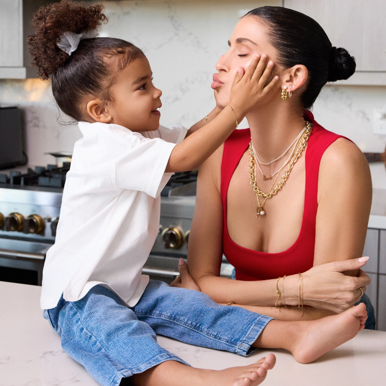 Nicole English Williams in Babygold jewelry with daughter India in kitchen.