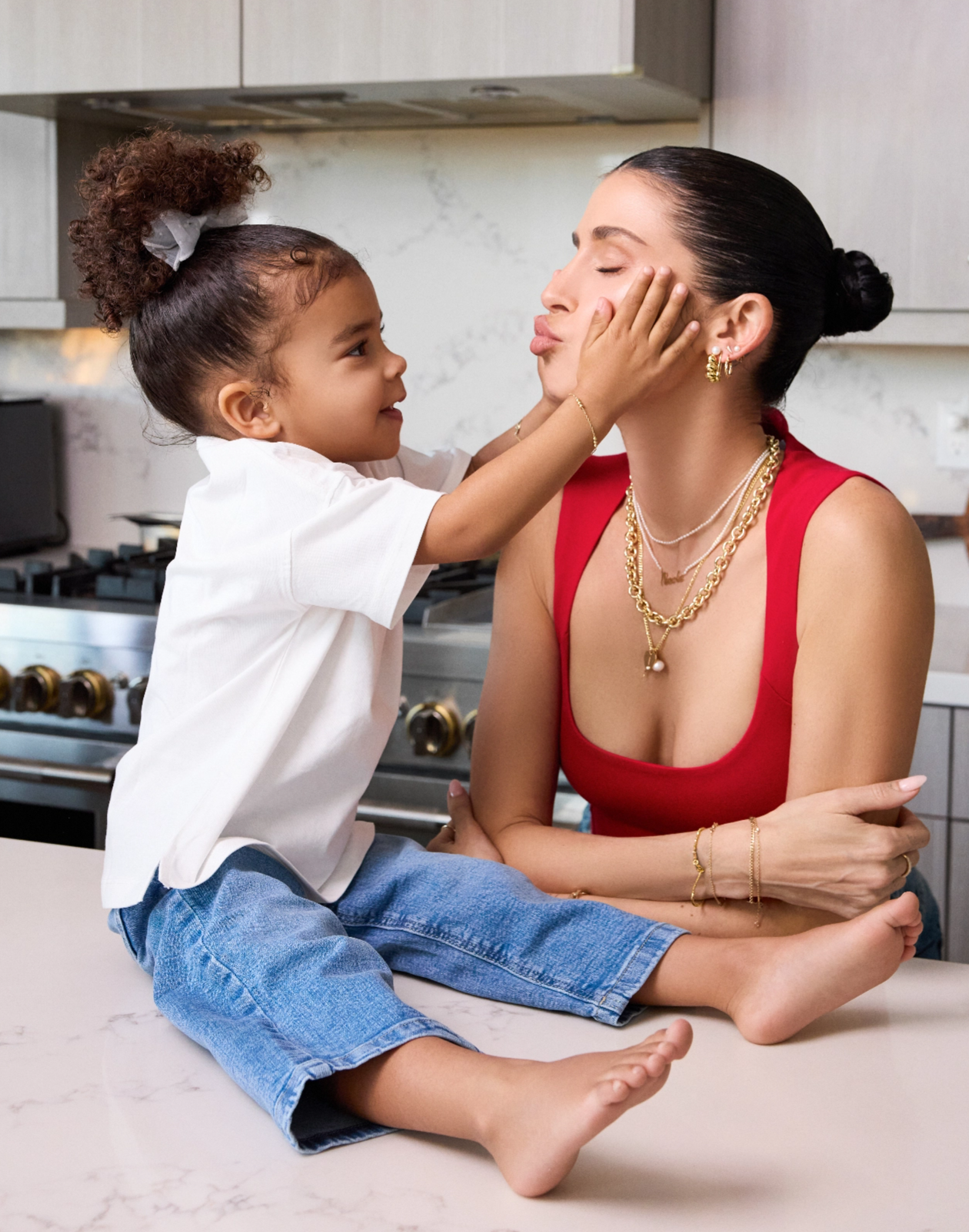 Nicole English Williams in Babygold jewelry with daughter India in kitchen.