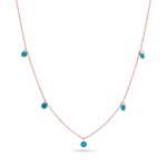 A 14k solid rose gold chain with 5 dainty turquoise beads draping off of it.