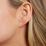 14k solid gold trio diamond stud earrings on model's ear.